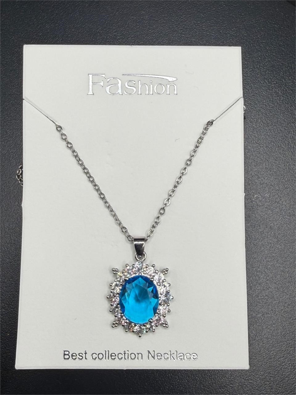 Elegant 2-carat aquamarine style crystal pendant necklace featuring a sparkling blue gemstone on a silver chain.
