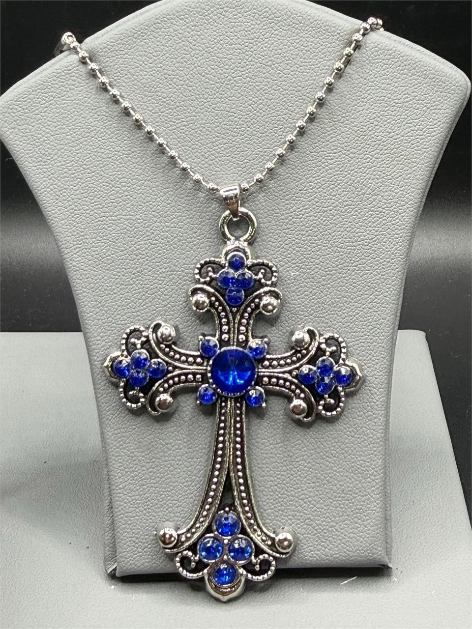 Large blue crucifix pendant necklace on silver chain by Republic Mercantile, featuring a detailed cross design with a vibrant blue centerpiece.