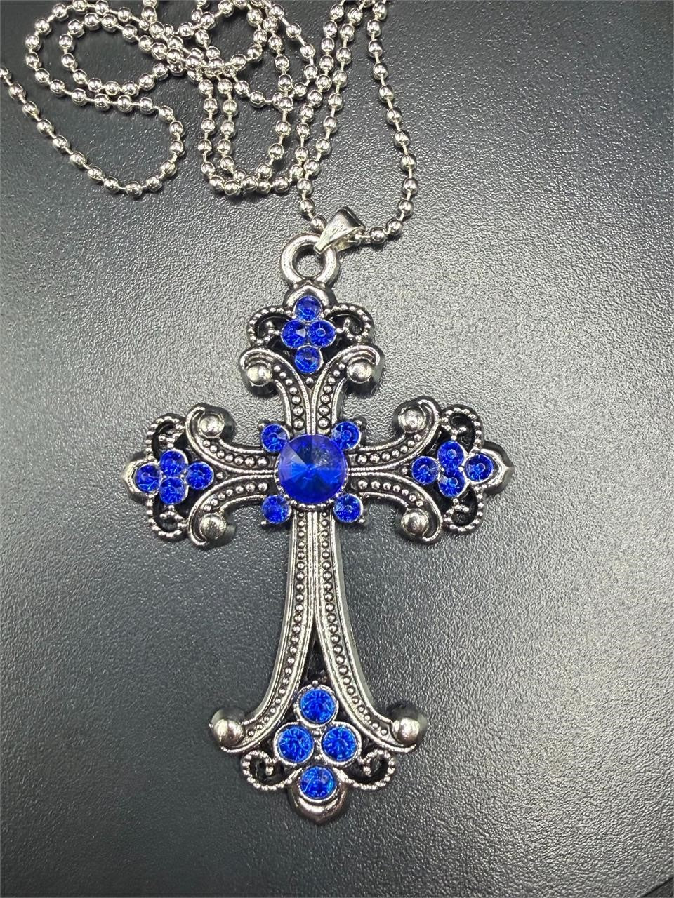 Large blue on silver crucifix pendant necklace featuring a detailed crucifix with a blue accent on a silver chain.