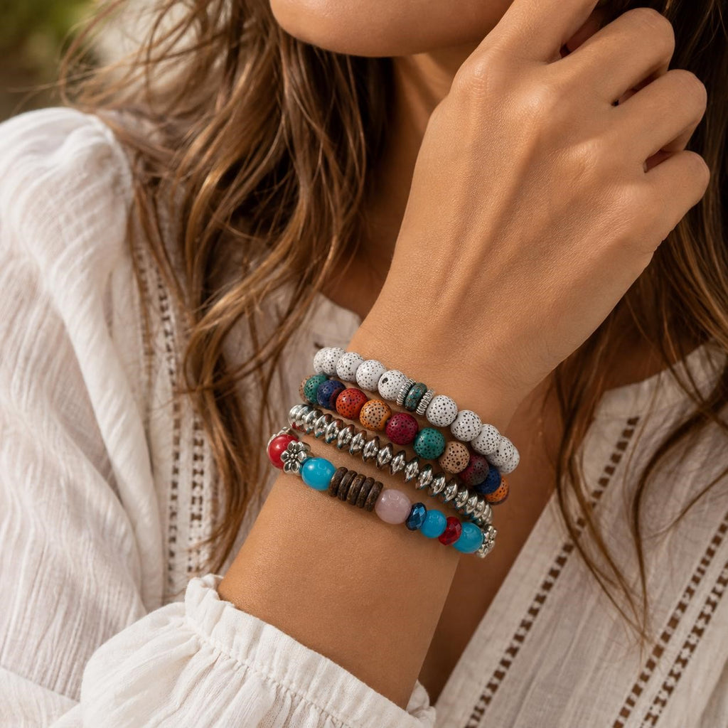 Handcrafted 4 strand boho beaded charm bracelet with colorful beads and metal charms, stylishly worn on a wrist.