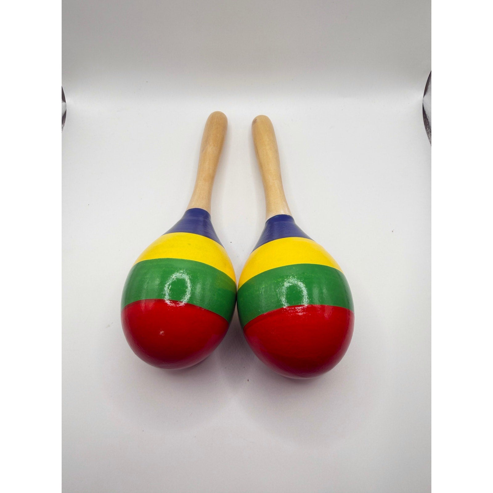 Pair of colorful wooden Latin maracas with vibrant patterns, perfect for rumba shakers and musical performances.
