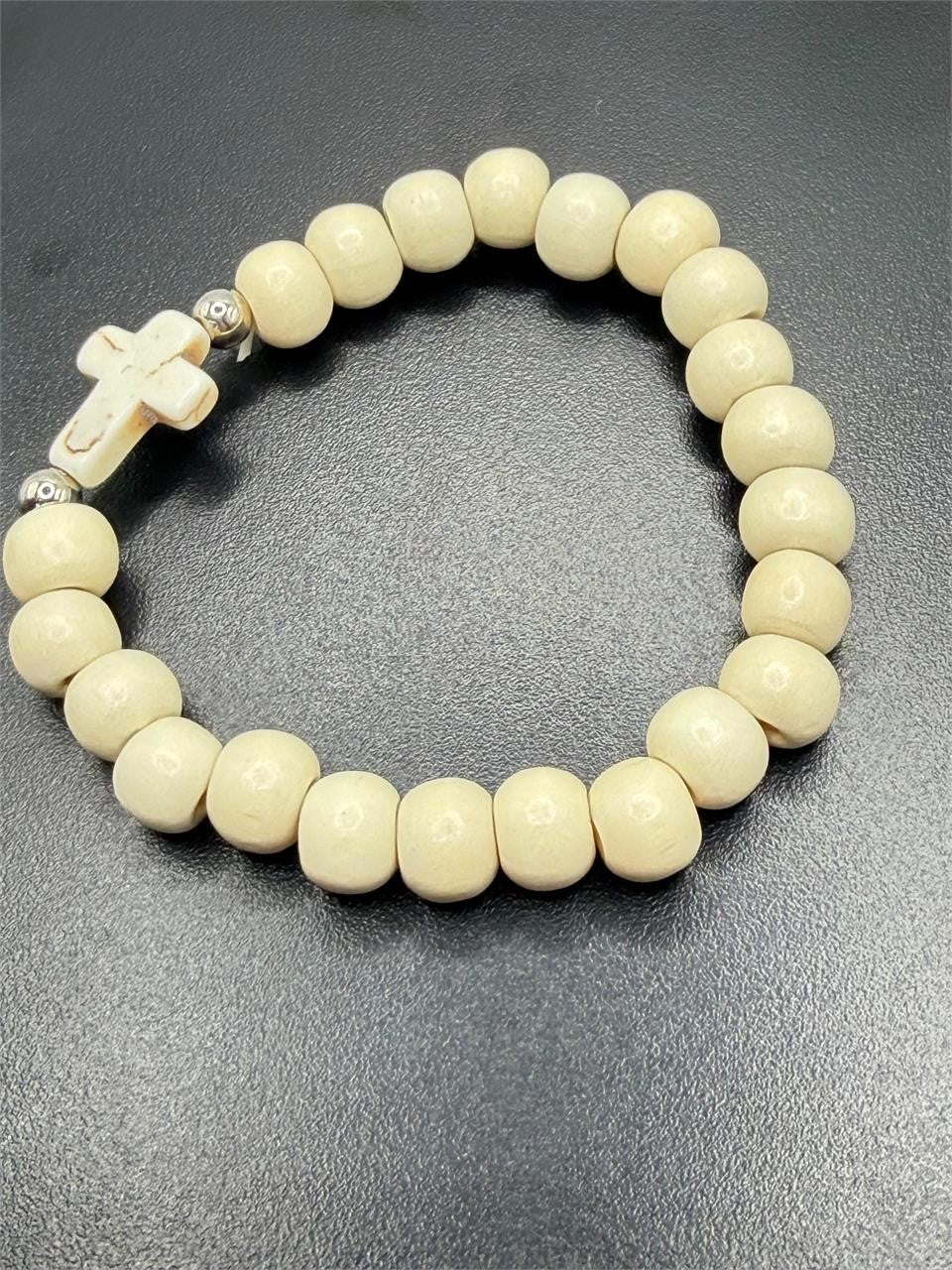 White beaded bracelet with a cross charm from Republic Mercantile, featuring intricate beadwork and a spiritual design.