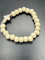White beaded bracelet with a cross charm from Republic Mercantile, featuring intricate beadwork and a spiritual design.
