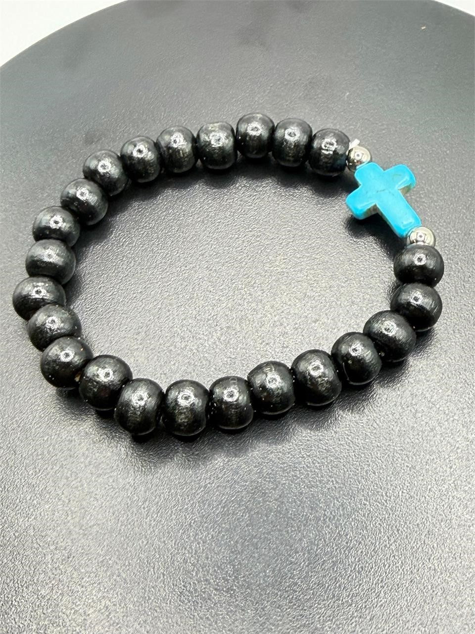 Beaded black bracelet with a blue cross charm from Republic Mercantile featuring intricate beadwork and a stylish design.