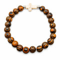 Beaded bracelet with tiger wood beads and white cross charm, handmade jewelry from Republic Mercantile.