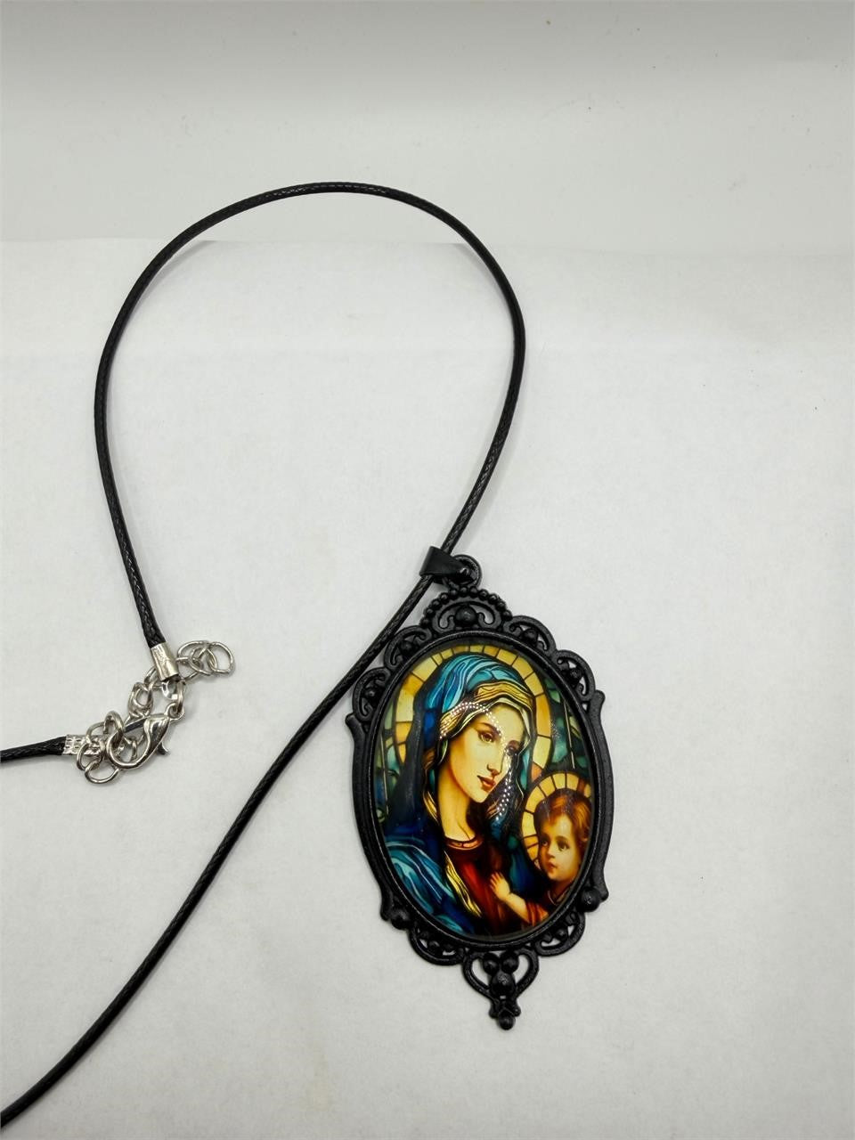 Black Virgin Mary pendant necklace with rope chain from Republic Mercantile, showcasing religious jewelry on a neutral background.