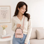Pink Aohao heart-shaped faux leather crossbody backpack with zipper closure, stylish and compact for everyday use.