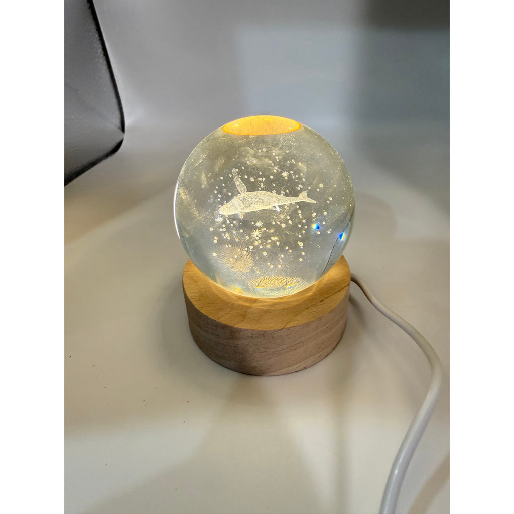 Laser etched crystal ball featuring a blue whale design on an LED stand, by Republic Mercantile.