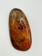Polished banded agate gemstone cabochon from Republic Mercantile showcasing smooth, colorful layered patterns and polished surface.