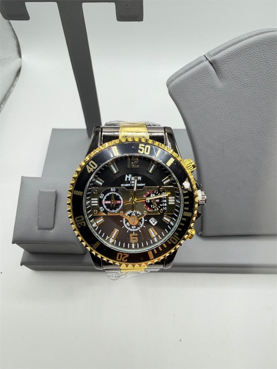 Men's black and gold Republic Mercantile Hkun watch with case and band, featuring a sleek design and detailed dial.