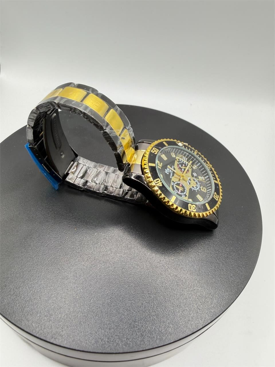 Men's Hkun black and gold case and band watch by Republic Mercantile, showing close-up of sleek design and detailed watch face.
