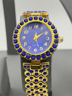 Women's gemstone watch in blue on gold band, Republic Mercantile, featuring a round face with gemstone accents.