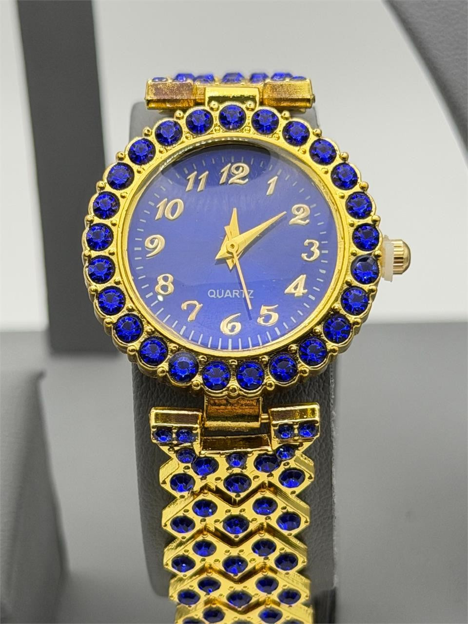Women's gemstone watch in blue on gold band, Republic Mercantile, featuring a round face with gemstone accents.
