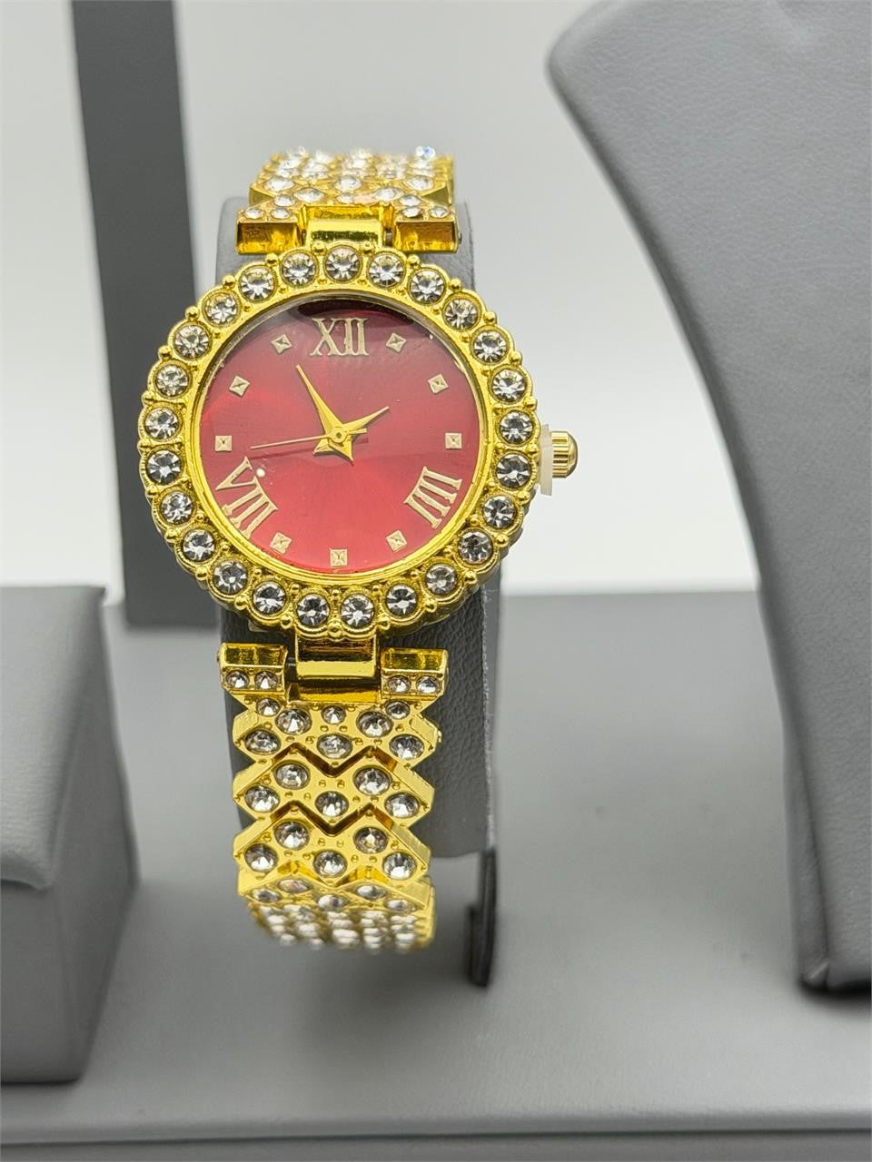Women's gemstone watch with a red face on a gold band from Republic Mercantile, showcasing elegant jewelry design.