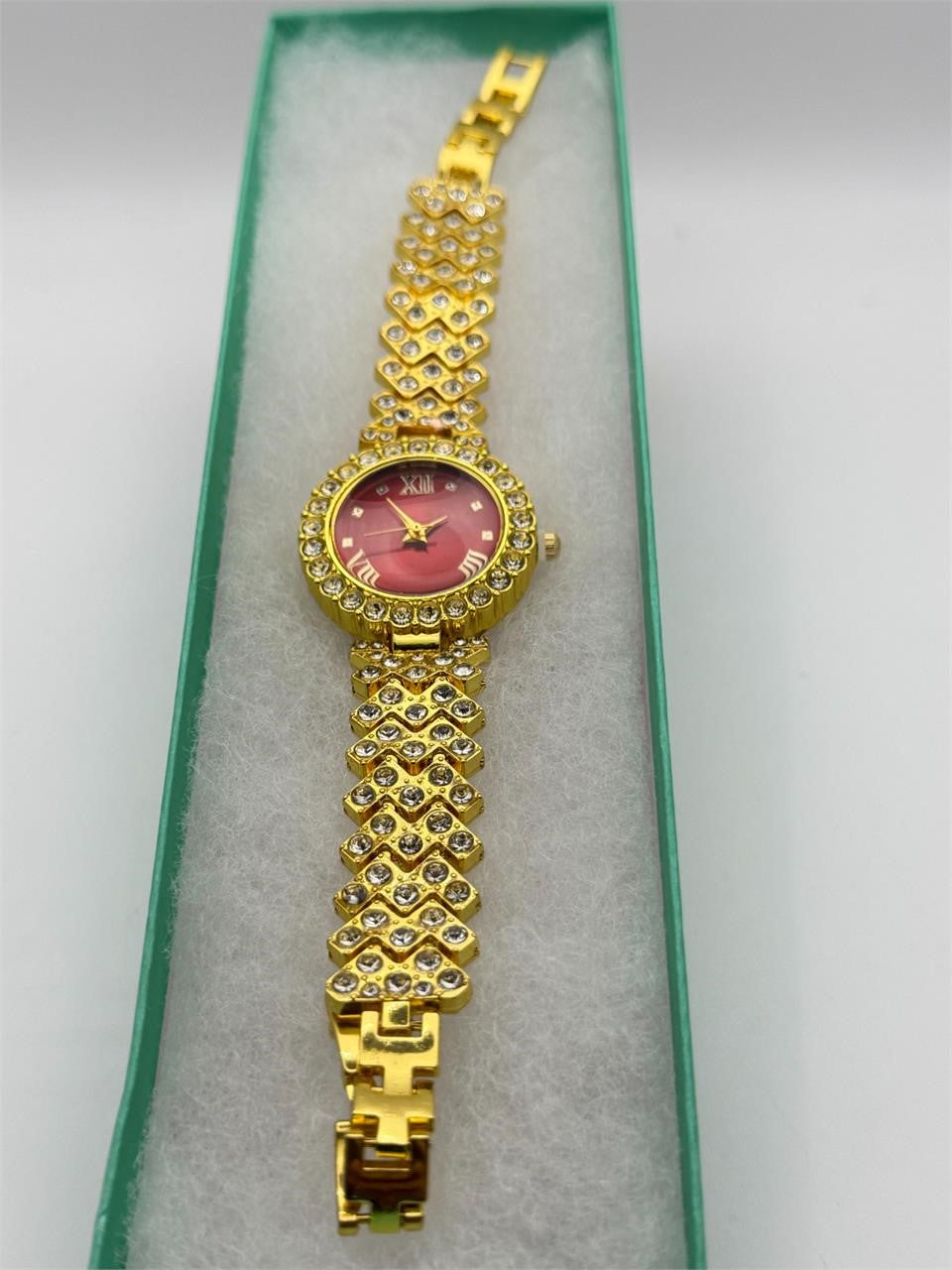 Women's gemstone watch with red dial on gold-tone band by Republic Mercantile, showcasing elegant jewelry timepiece design.