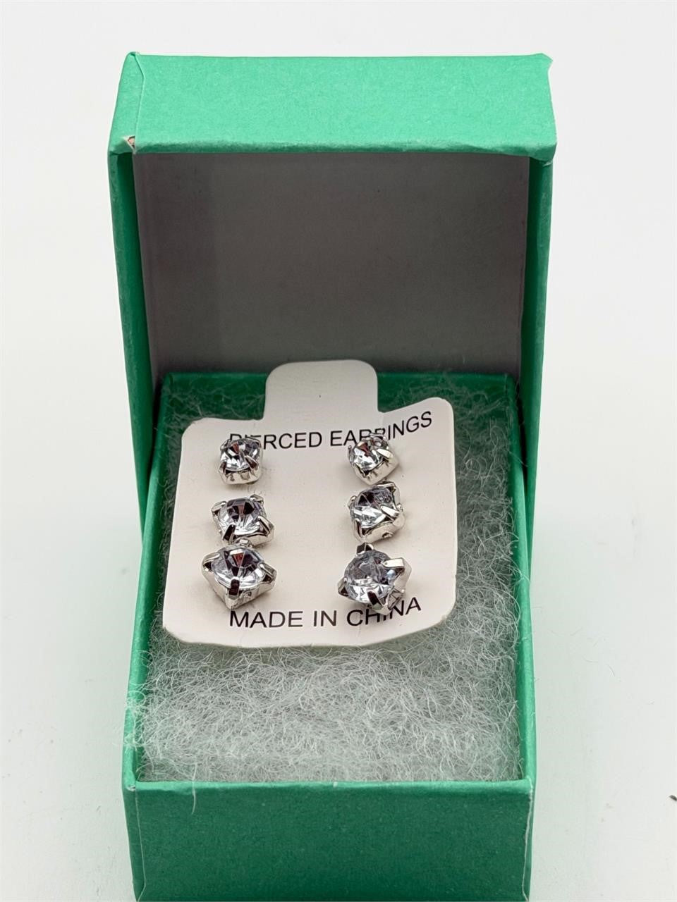 Three pairs of crystal clear gem earrings in small, medium, and large from Republic Mercantile displayed on a white background.