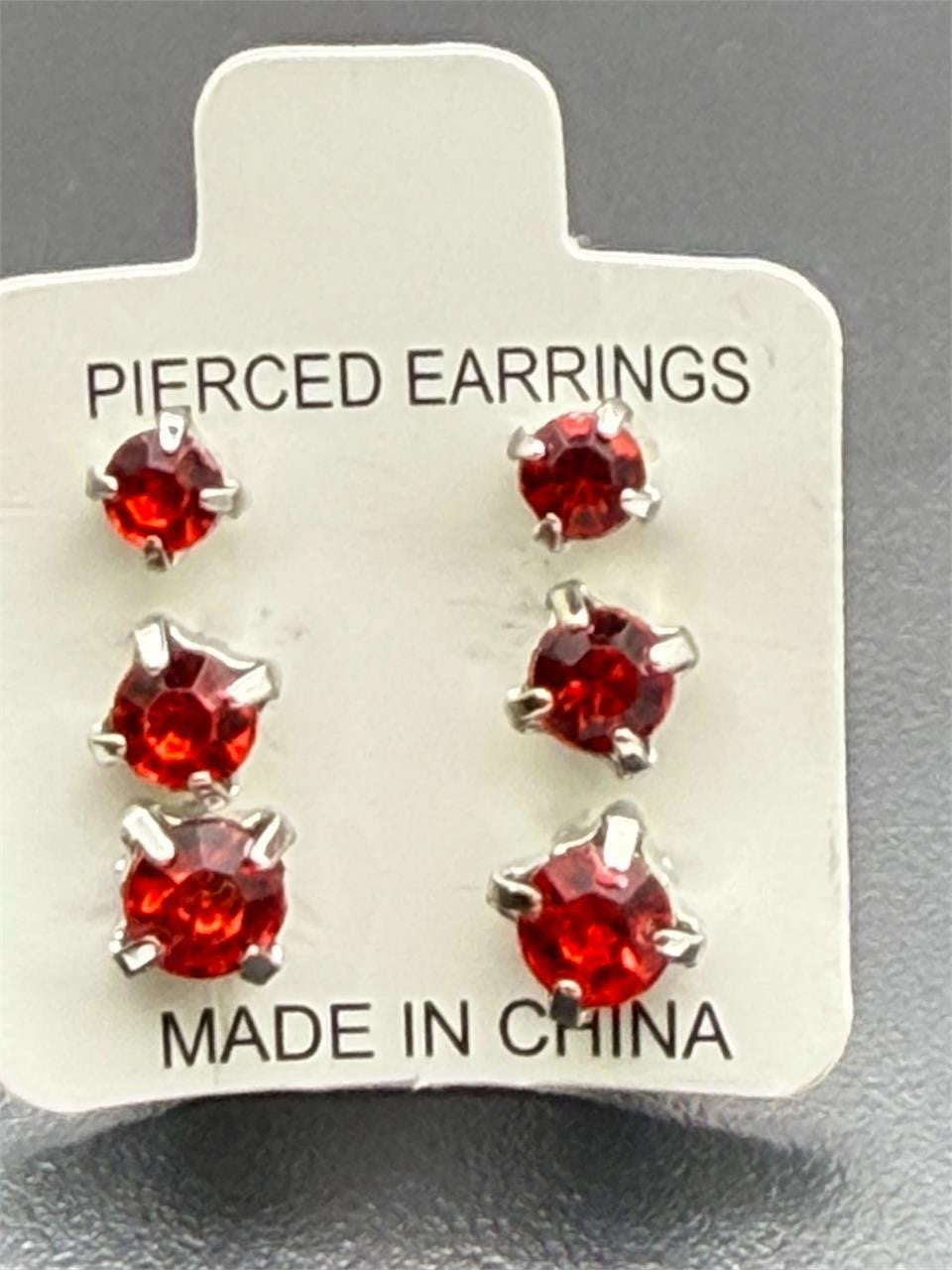 Three pairs of red crystal gem earrings in small, medium, and large sizes from Republic Mercantile displayed on a white background.