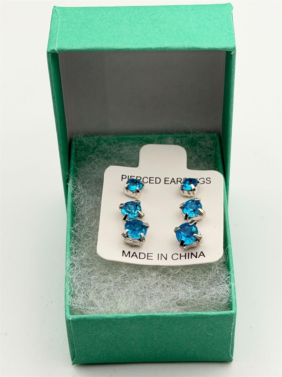 Three pairs of blue crystal gem earrings in small, medium, and large sizes, featuring sparkling blue crystals and silver settings.