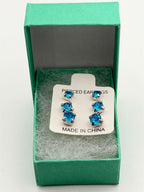 Three pairs of blue crystal gem earrings in small, medium, and large sizes, featuring sparkling blue crystals and silver settings.
