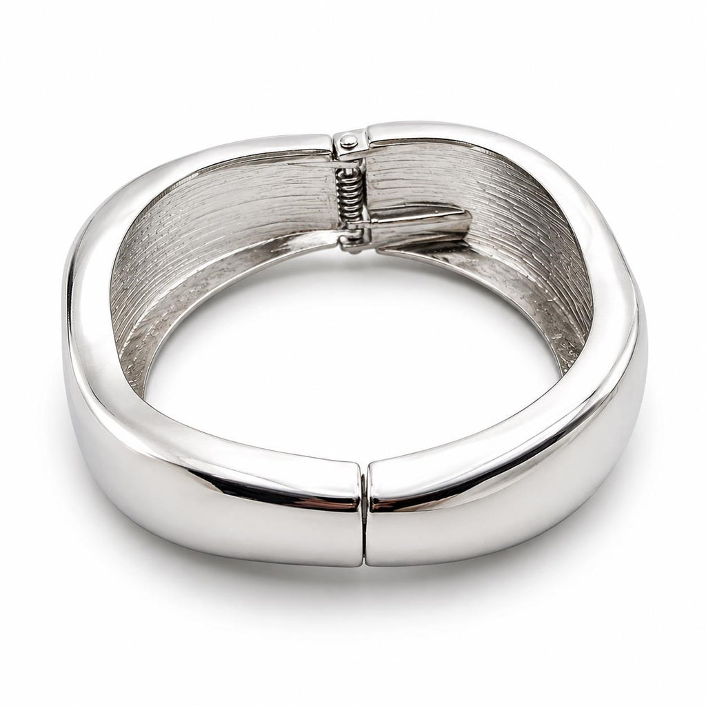 Silver tone large spring action bangle bracelet with a sleek, modern design, featuring smooth, shiny metal finish.