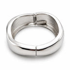 Silver tone large spring action bangle bracelet with a sleek, modern design, featuring smooth, shiny metal finish.