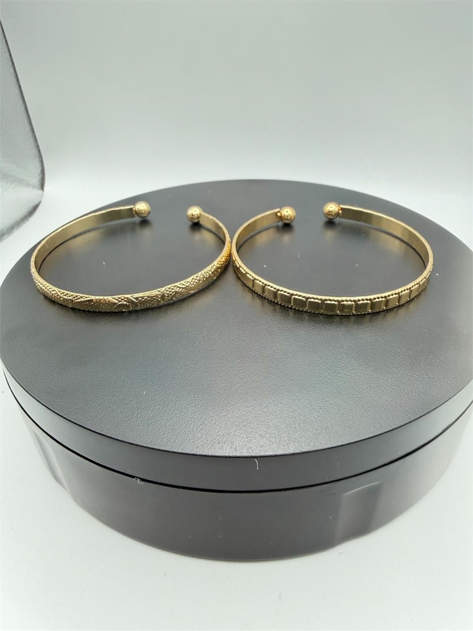 Two gold tone bangle bracelets from Republic Mercantile, showcasing sleek, matching jewelry with polished finishes.
