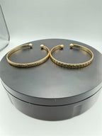 Two gold tone bangle bracelets from Republic Mercantile, showcasing sleek, matching jewelry with polished finishes.