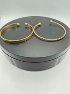 Two gold tone bangle bracelets from the Republic Mercantile 2-piece set, featuring sleek, shiny metal designs.