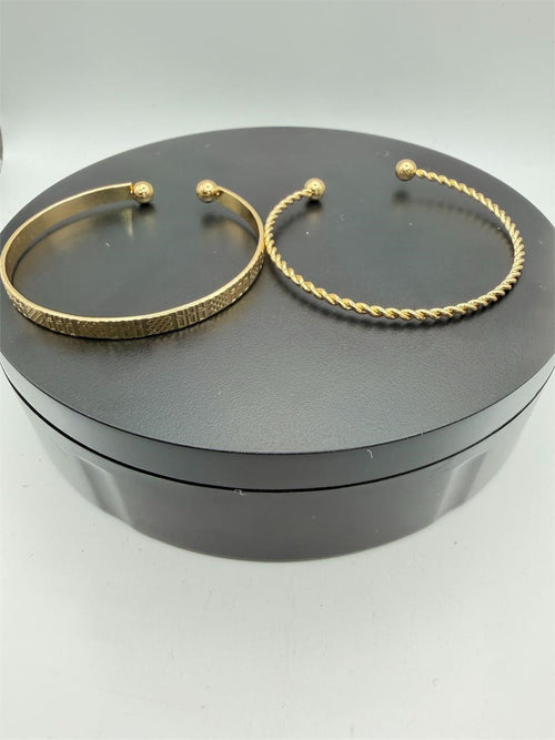 Two gold tone bangle bracelets from the Republic Mercantile 2-piece set, featuring sleek, shiny metal designs.