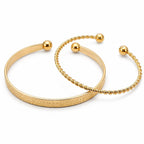 Two gold-tone bangle bracelets from the Republic Mercantile 2-piece set, featuring smooth, shiny finishes and sleek design.