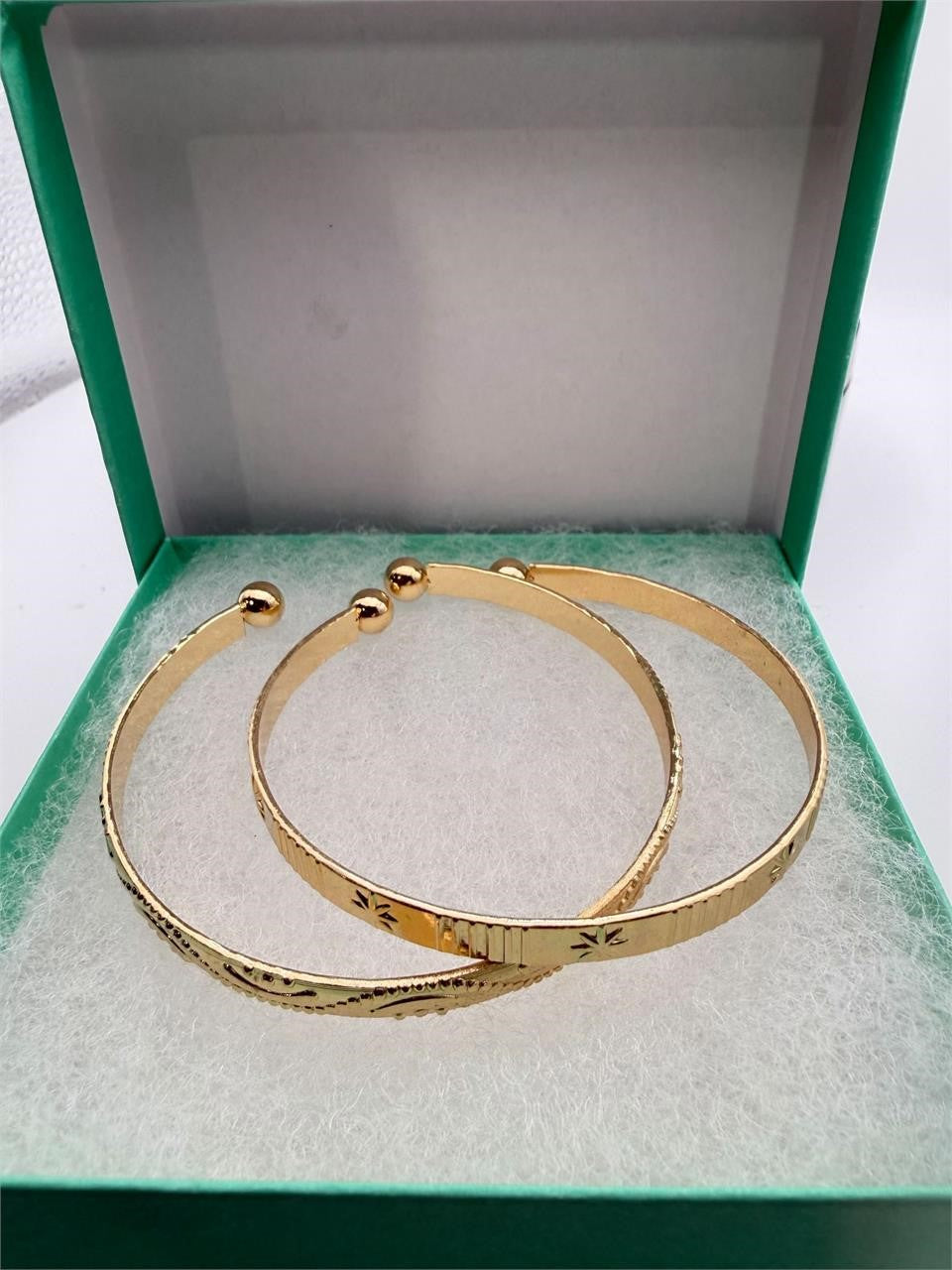 Two gold tone bangle bracelets from Republic Mercantile in a set, featuring sleek, shiny circular designs.
