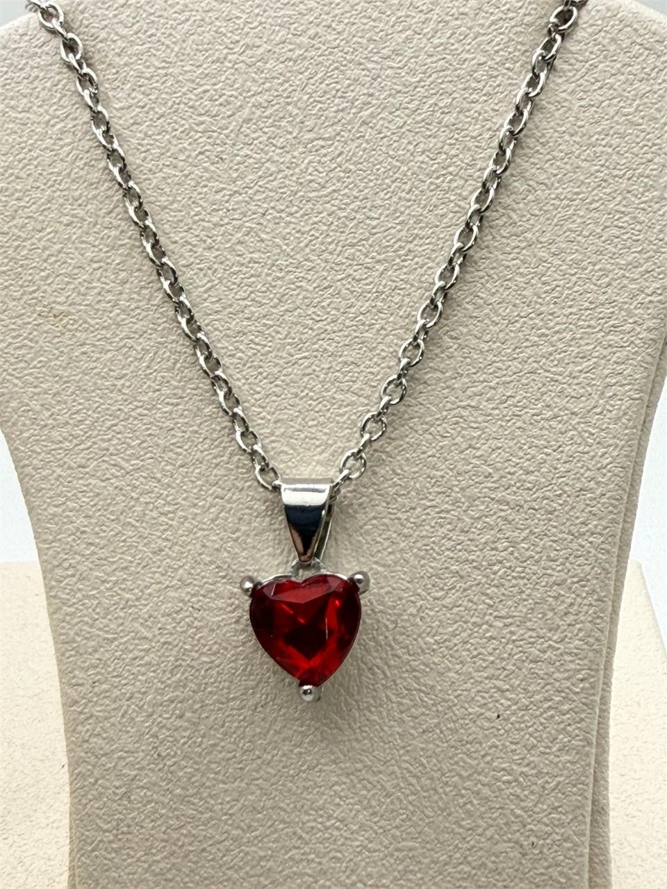 Silver heart gemstone pendant necklace with a chain, featuring a sparkling gemstone set in a delicate design.