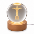 Laser etched crystal ball with LED stand featuring Christ design, crafted by Republic Mercantile, displayed on a black background.
