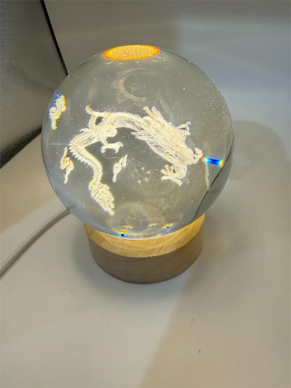Laser etched crystal ball featuring a dragon design on an LED stand, crafted by Republic Mercantile.