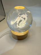 Laser etched crystal ball featuring a detailed dragon design on an LED stand, by Republic Mercantile.