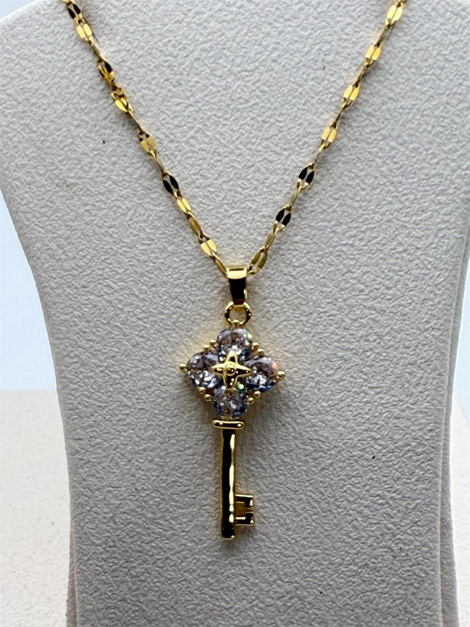 Gold tone crystal key pendant necklace with sparkling crystals and chain, stylish jewelry piece from Republic Mercantile.