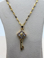Gold tone crystal key pendant necklace with sparkling crystals and chain, stylish jewelry piece from Republic Mercantile.