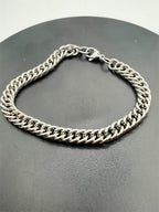Men's stainless steel Cuban link bracelet by Republic Mercantile, showcasing shiny, interlocking chain design.