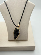 Black arrowhead pendant necklace with gold tone chain, Republic Mercantile jewelry, showcasing a stylish, boho-inspired design.