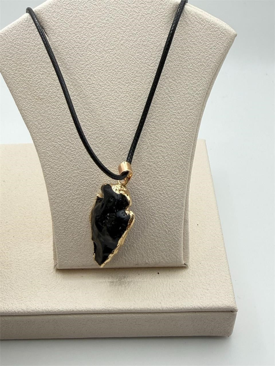 Black arrowhead pendant necklace with gold tone chain, Republic Mercantile jewelry, showcasing a stylish, boho-inspired design.