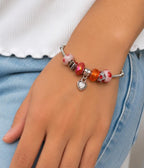 Handcrafted charm bracelet from Divine Designs featuring silver and beaded charms on a delicate chain.