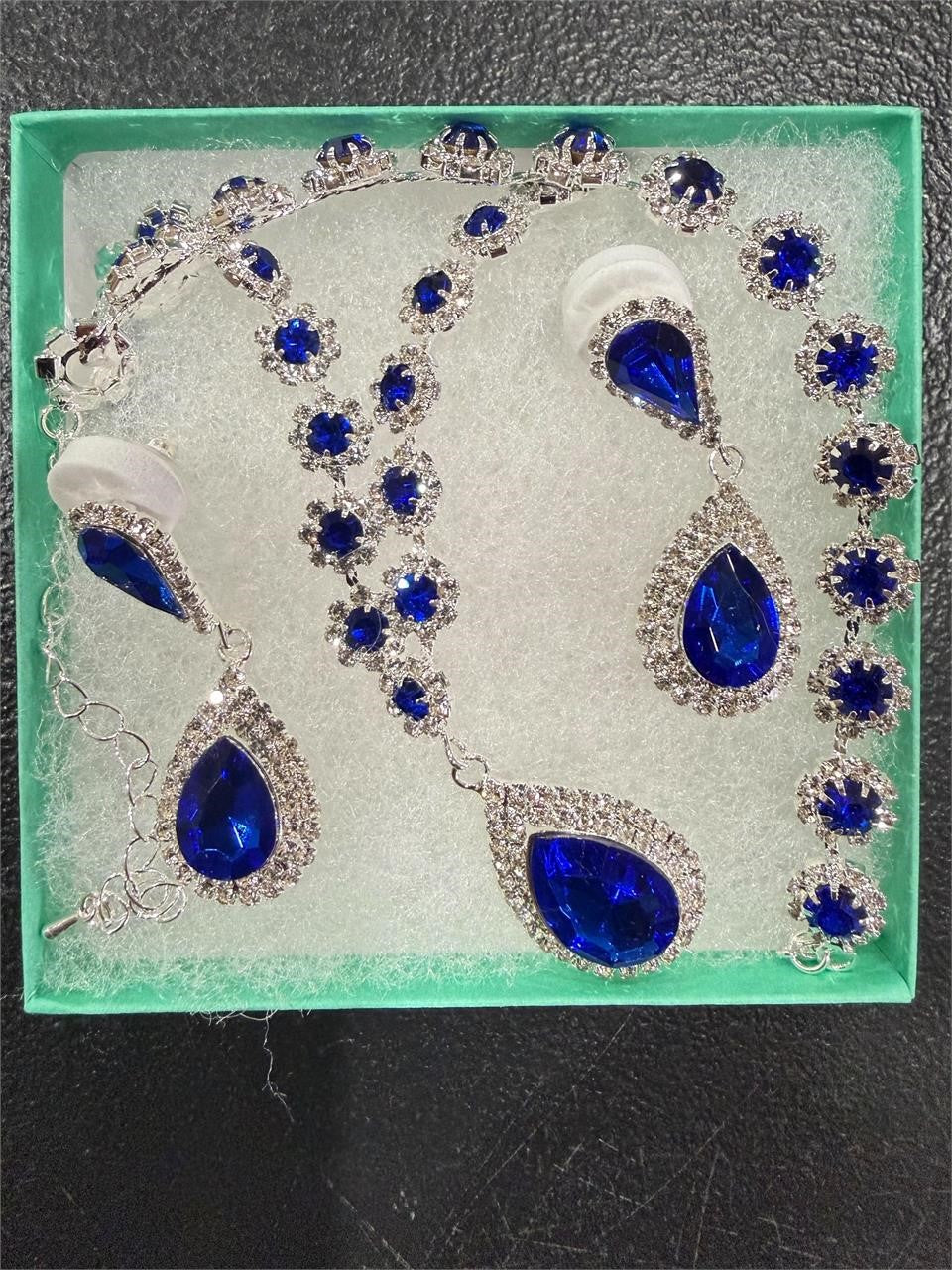 Four-piece fashion jewelry set featuring sapphire and diamond accents, including earrings, necklace, and bracelet by Republic Mercantile.