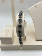 Beautiful blue tanzanite gemstone women's bracelet with silver setting, featuring sparkling oval stones and intricate design.