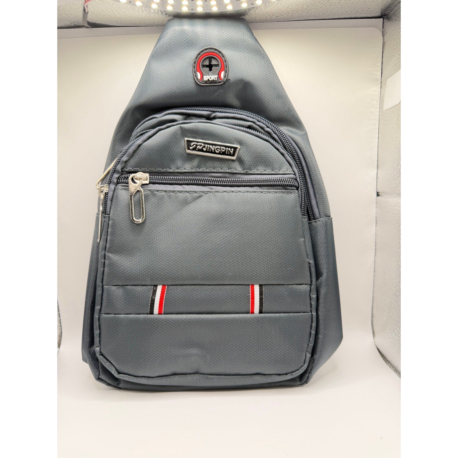 Gray Jingpin Daily Single Strap Crossbody Backpack for unisex use, featuring a sleek design and adjustable strap.